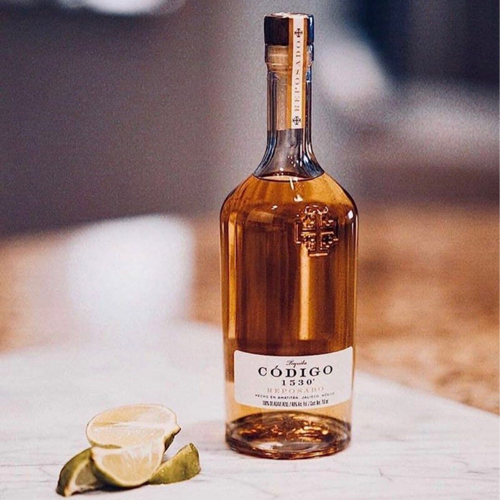 Load image into Gallery viewer, Bottle of Codóigo 1530 reposado tequila with a slice of lime on a marble surface