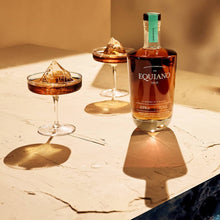Load image into Gallery viewer, Bottle of Equiano rum with cocktails on a textured surface, with an ocean scene overlay.