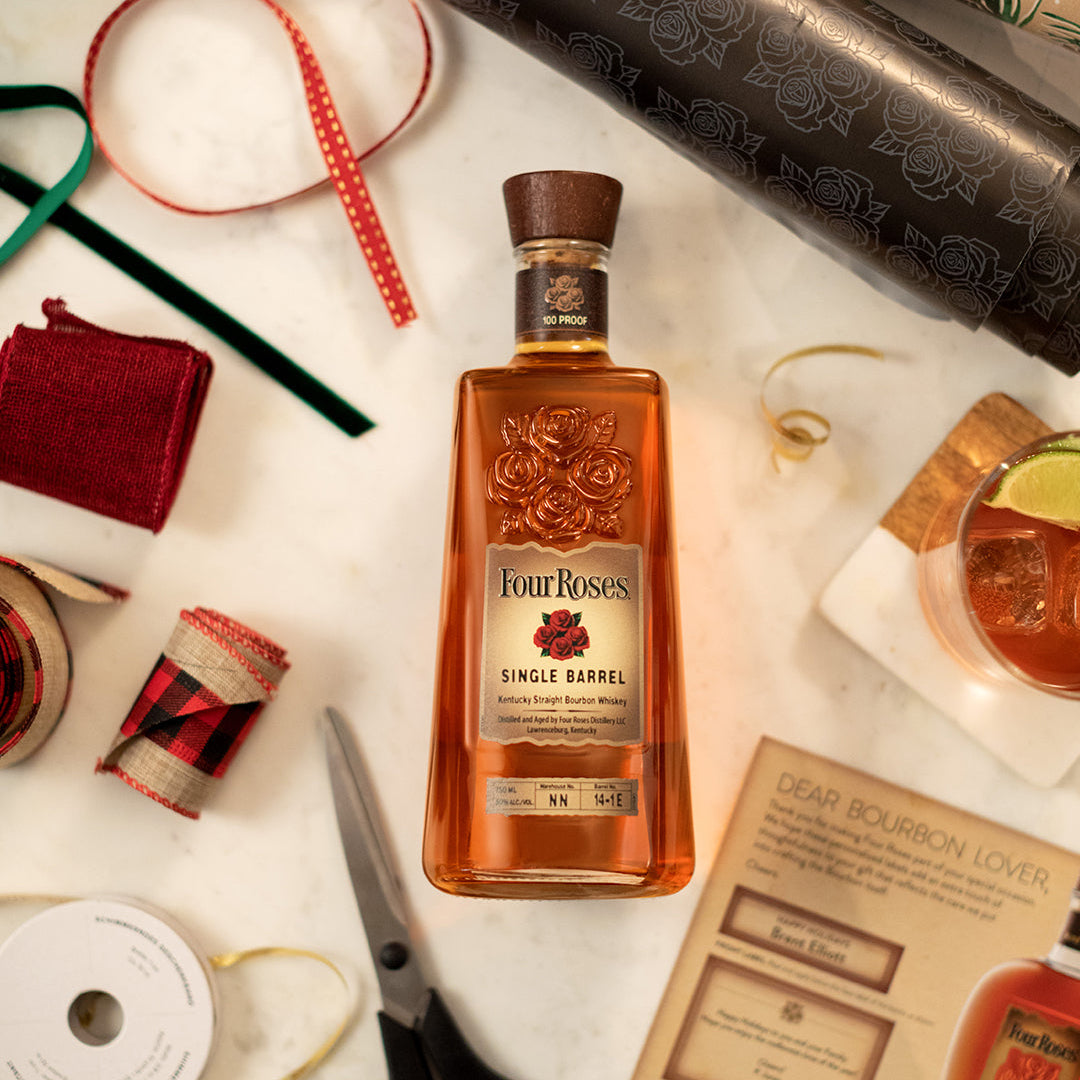 Load image into Gallery viewer, Four Roses bourbon bottle on a festive background with holiday decor