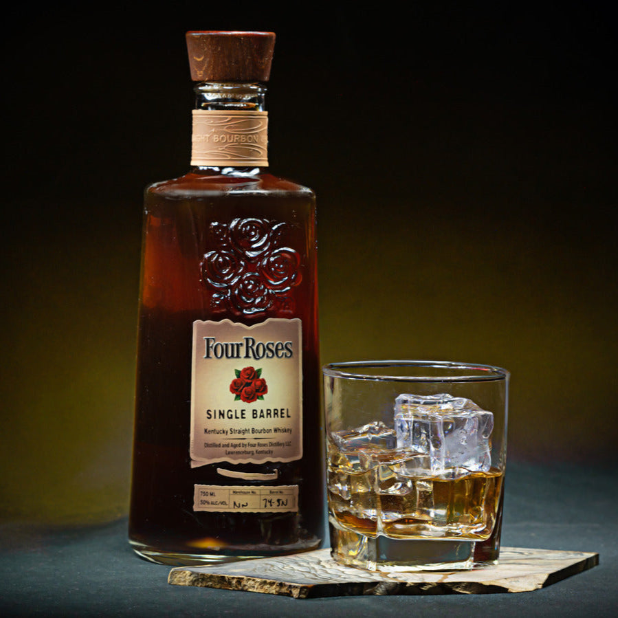 Load image into Gallery viewer, Four Roses whiskey bottle with a glass of whiskey on a dark background