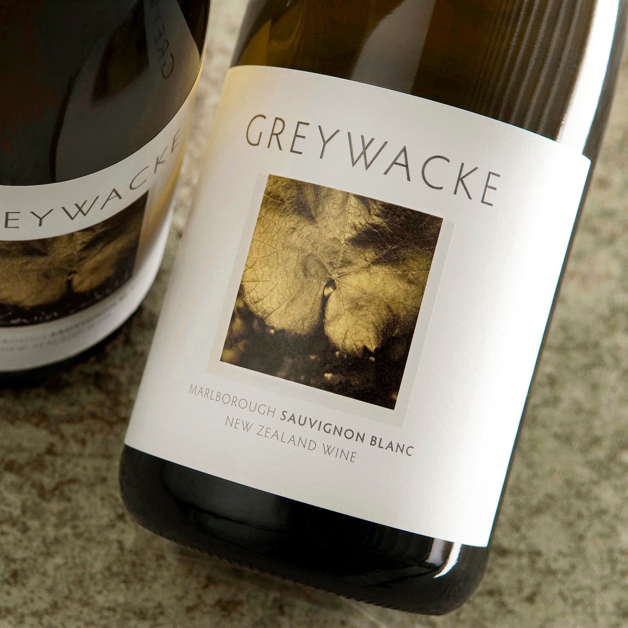 Load image into Gallery viewer, Two bottles of Greywacke Sauvignon Blanc wine on a stone surface.