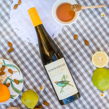 Load image into Gallery viewer, Hawkshead wine bottle on a checkered tablecloth with fruits and honey dipper.