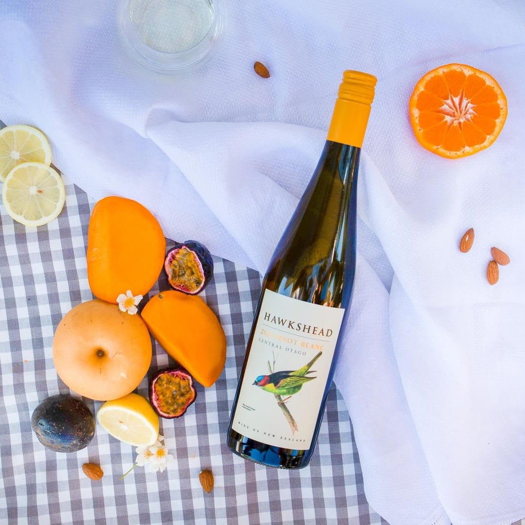 Load image into Gallery viewer, A bottle of Hawkshead Pinot Gris on a white cloth and some fruit