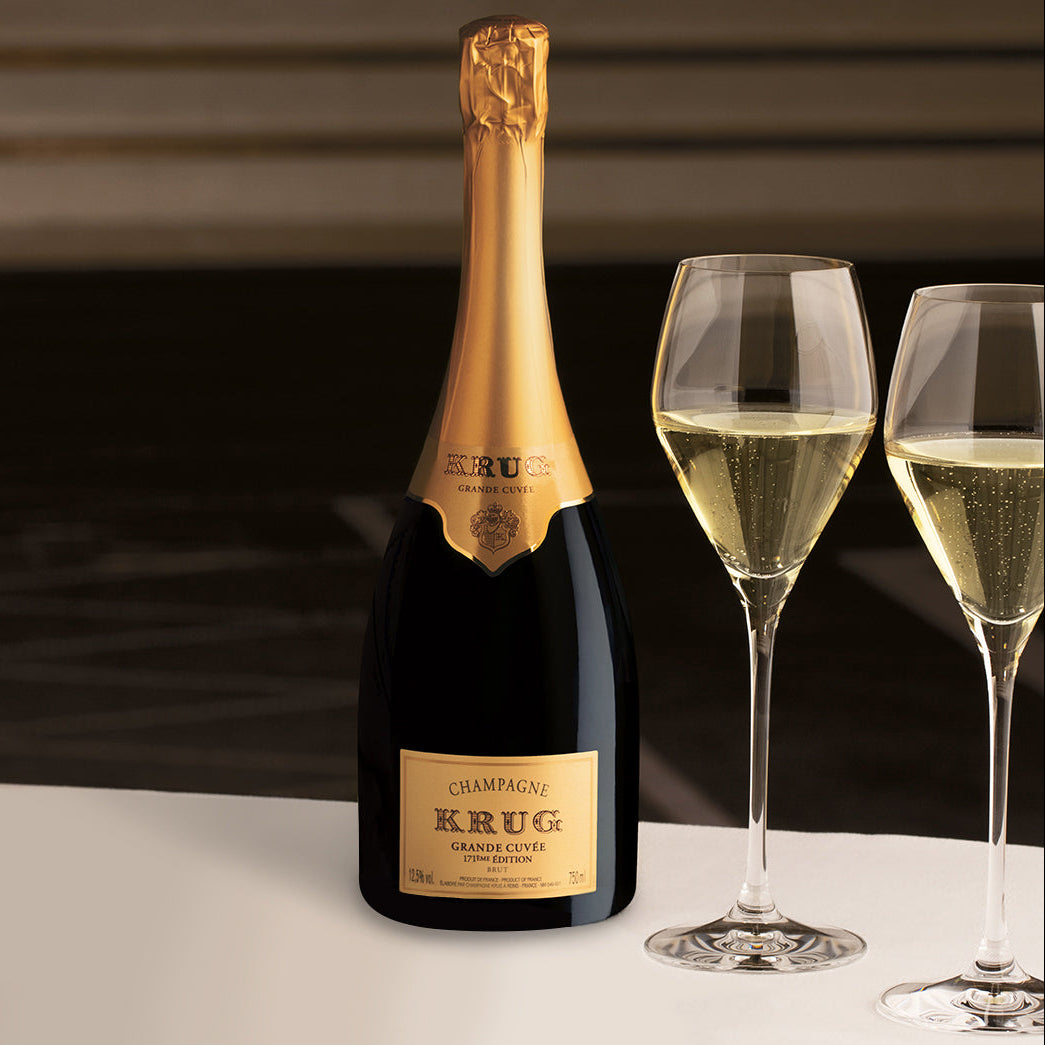 Load image into Gallery viewer, Bottle of Krug champagne with two filled glasses on a dark background