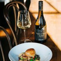 Load image into Gallery viewer, Wine bottle and glass with a dish on a wooden table