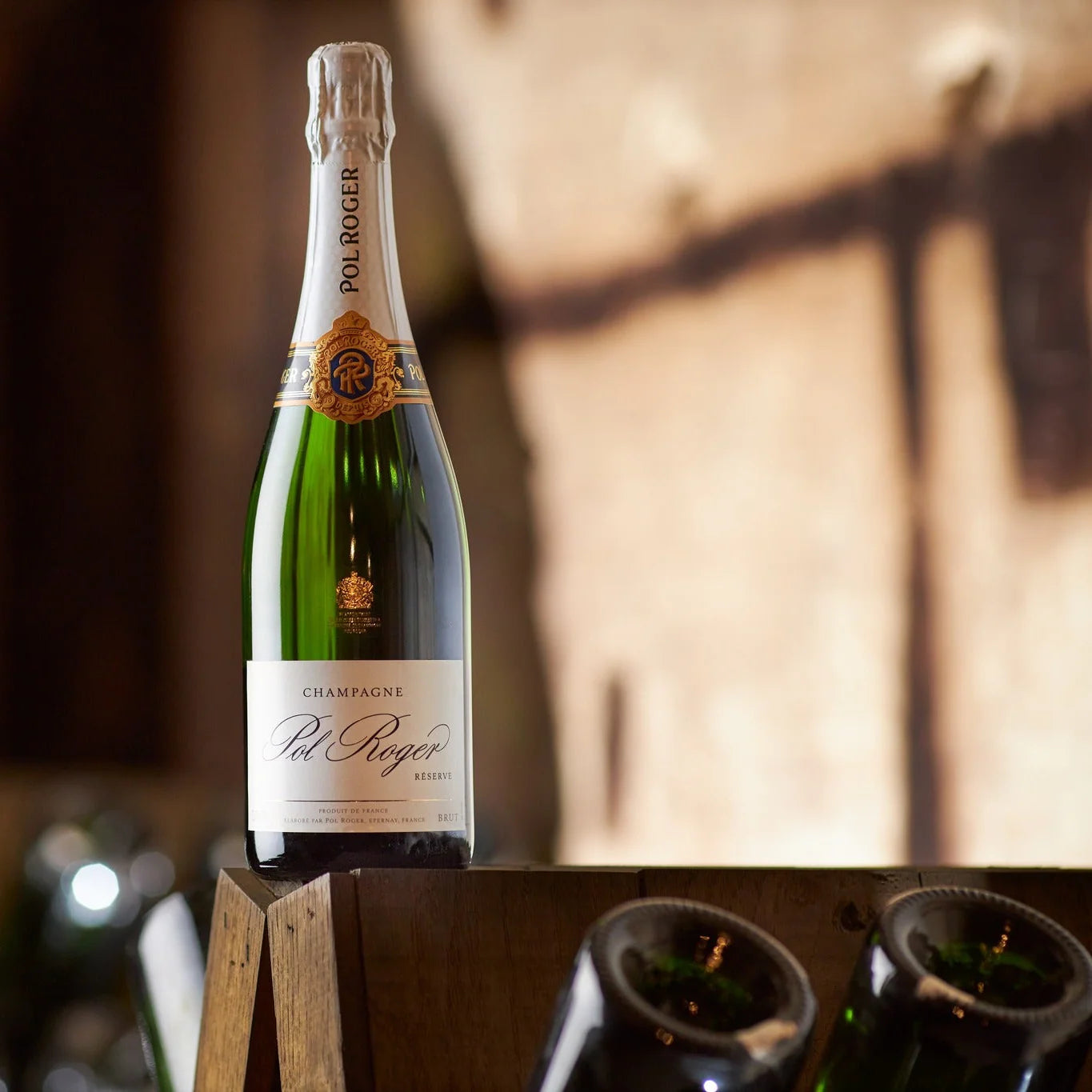 Load image into Gallery viewer, Bottle of Pol Roger champagne on a wooden stand with blurred background