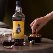 Load image into Gallery viewer, Sandeman Port bottle with a glass of port and snacks on a table