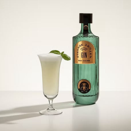 Load image into Gallery viewer, Bottle of gin with a glass of cocktail on a white background