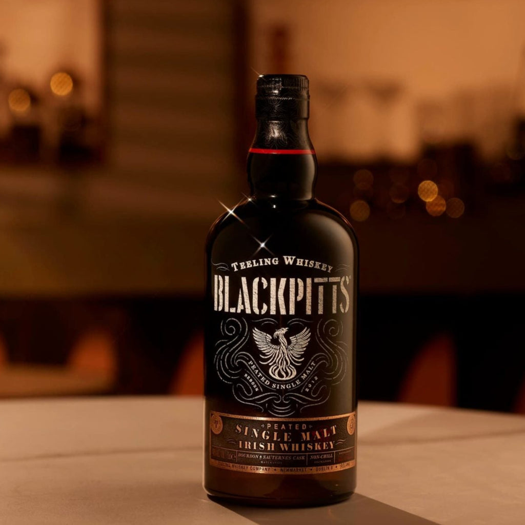 BlackPitts whiskey bottle on a bar counter with blurred bar background