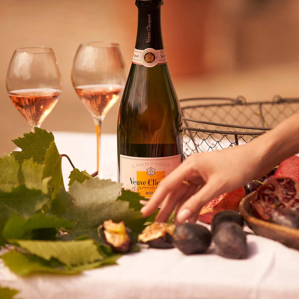 Veuve Clicquot champagne bottle with two glasses and figs on a table