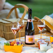 Load image into Gallery viewer, Bottle of Veuve Clicquot with two glasses of rose wine on a picnic blanket outdoors.