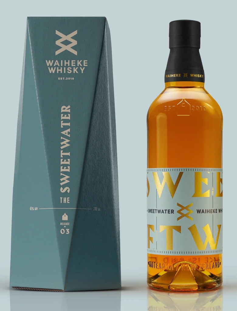 An image of a bottle of Waiheke Whisky Sweatwater Single Malt Whisky 700ml next to its stunning blue gift box